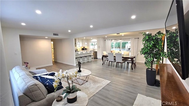 living room with sink and light hardwood / wood-style flooring