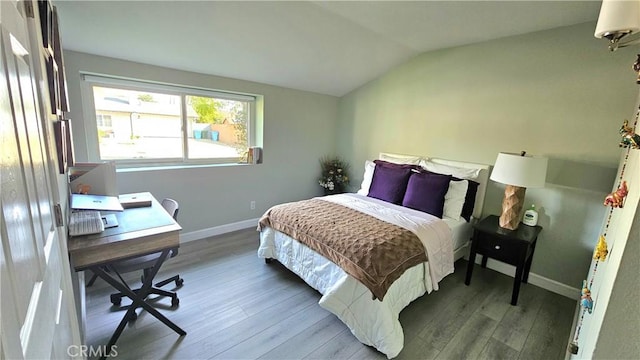 bedroom with vaulted ceiling and hardwood / wood-style floors