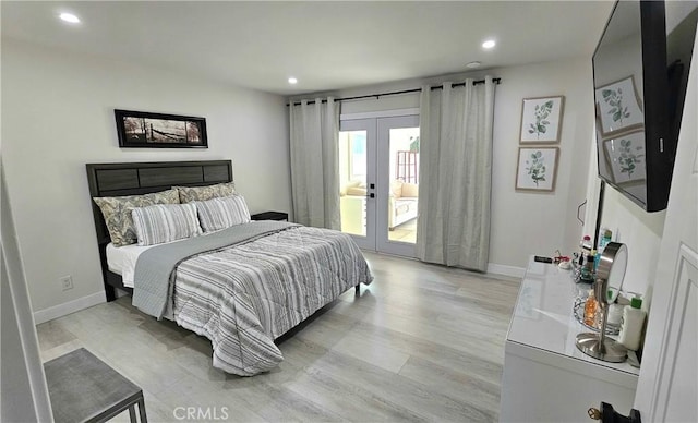 bedroom with access to exterior, light wood-type flooring, and french doors