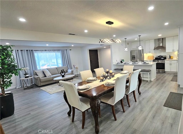 dining area featuring light hardwood / wood-style flooring and a textured ceiling