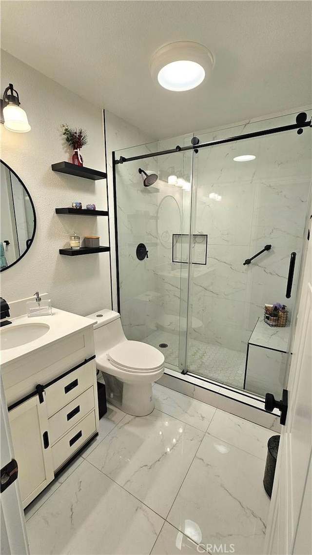 bathroom featuring vanity, toilet, a shower with shower door, and a textured ceiling