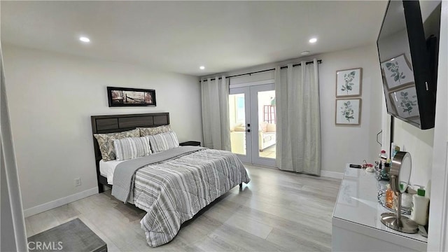 bedroom featuring access to exterior, light hardwood / wood-style flooring, and french doors