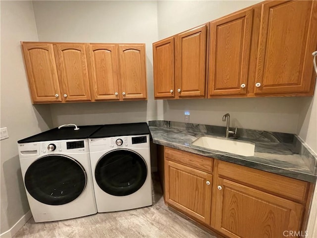 laundry room with cabinet space, washer and clothes dryer, and a sink