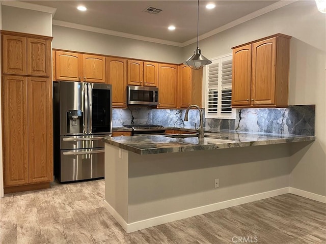 kitchen with a peninsula, brown cabinetry, visible vents, and stainless steel appliances