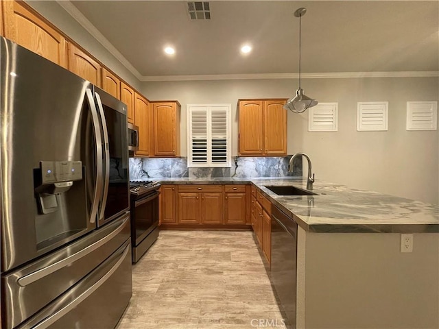 kitchen with visible vents, appliances with stainless steel finishes, decorative light fixtures, a sink, and backsplash