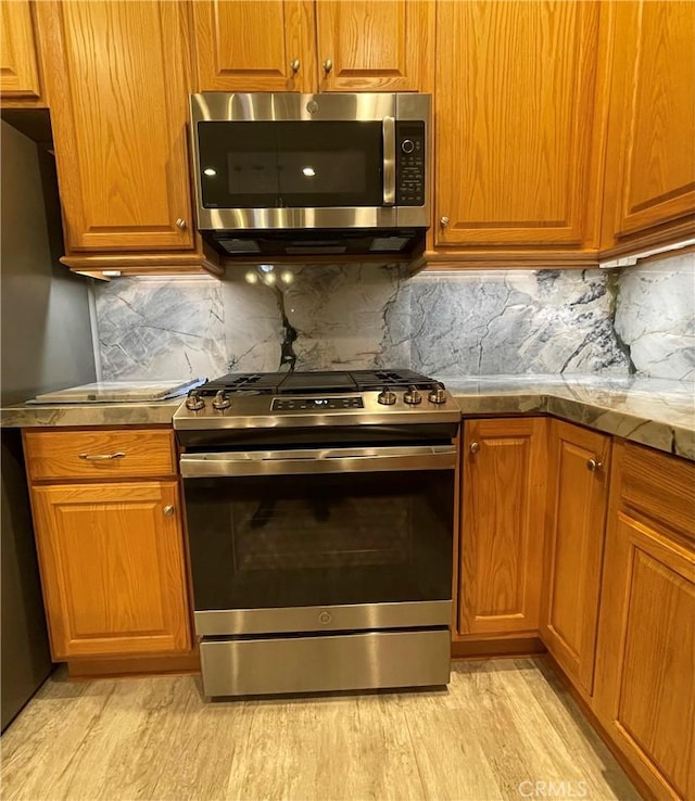 kitchen featuring light countertops, appliances with stainless steel finishes, and brown cabinetry