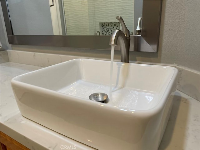 interior details with a textured wall and vanity