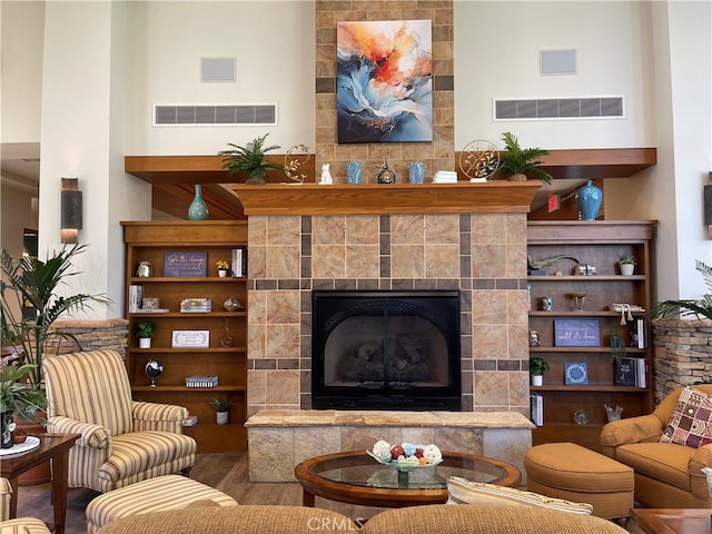 sitting room featuring a fireplace, wood finished floors, and visible vents