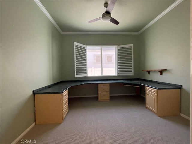 unfurnished office featuring a ceiling fan, ornamental molding, and built in desk