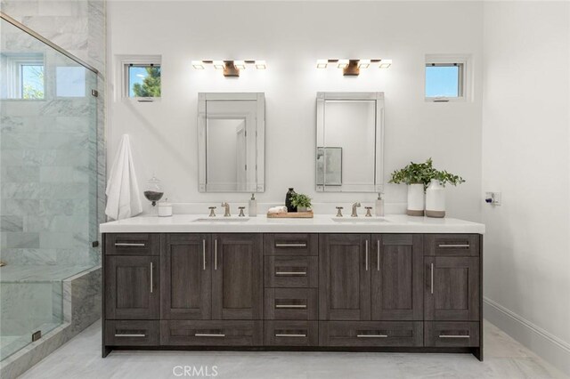 bathroom featuring a shower with door and vanity