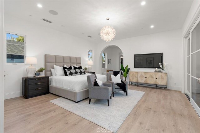 bedroom with an inviting chandelier and light hardwood / wood-style flooring