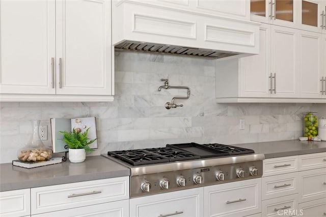 kitchen featuring decorative backsplash, stainless steel gas cooktop, and white cabinets