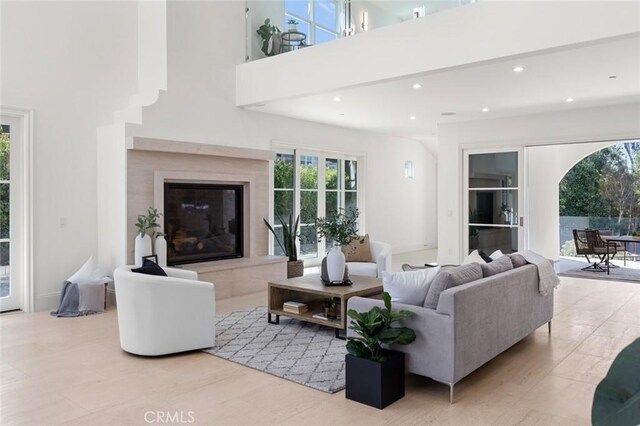 living room featuring a premium fireplace and a high ceiling