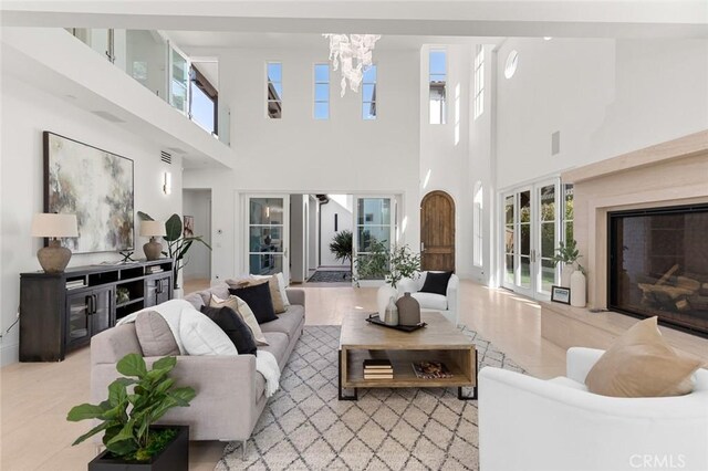 living room featuring an inviting chandelier and a high end fireplace