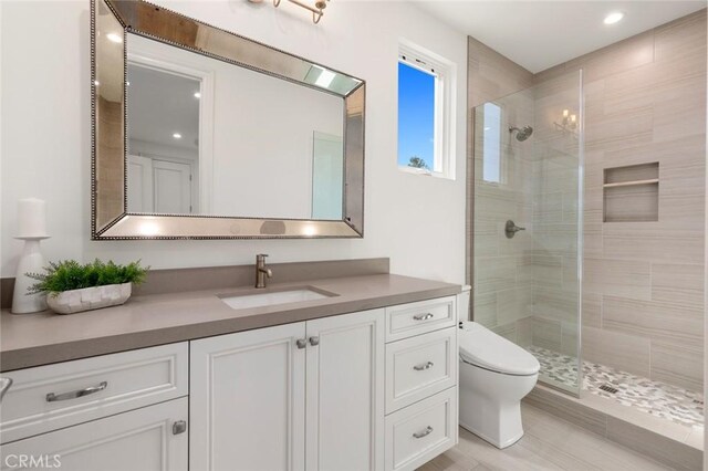 bathroom featuring vanity, toilet, and an enclosed shower