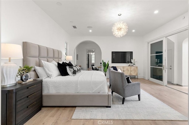 bedroom featuring a chandelier and light hardwood / wood-style flooring