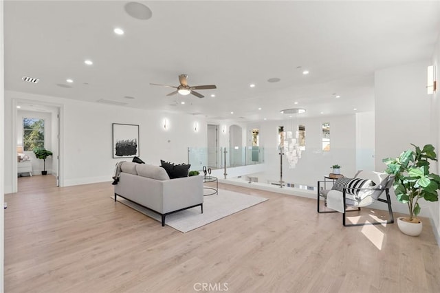 living room with ceiling fan and light hardwood / wood-style flooring