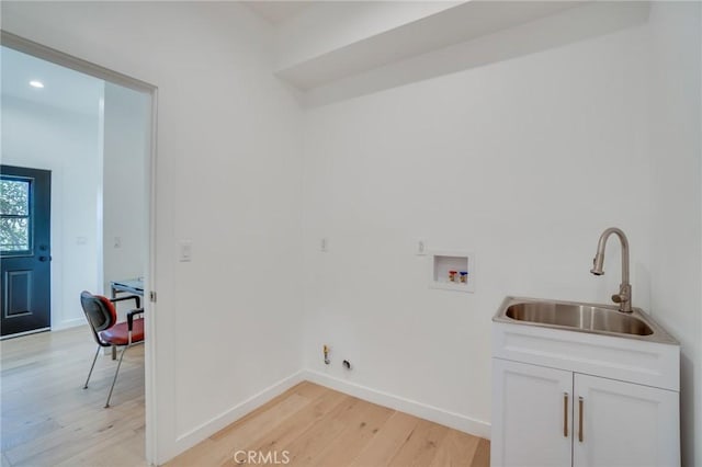 laundry area with cabinets, washer hookup, sink, and light hardwood / wood-style flooring