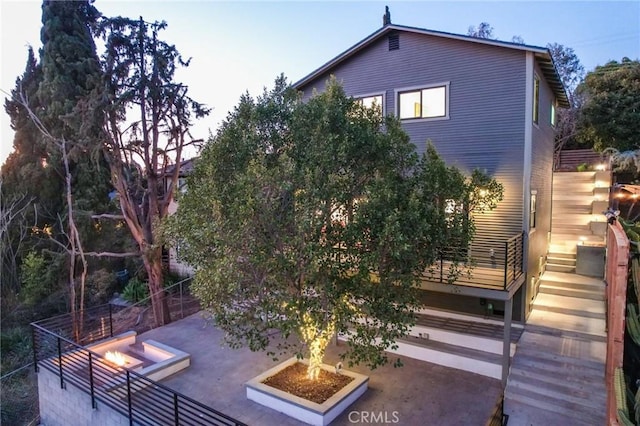 rear view of property with a fire pit and a patio area