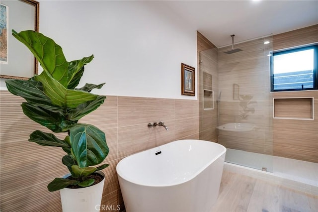 bathroom with independent shower and bath and tile walls