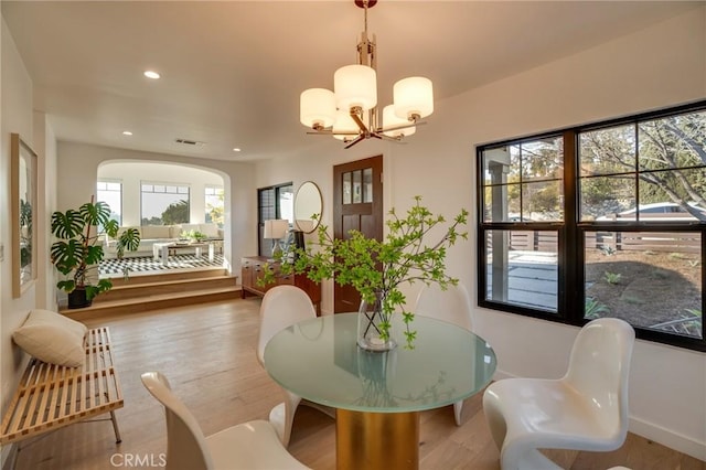 dining area featuring wood-type flooring and a notable chandelier