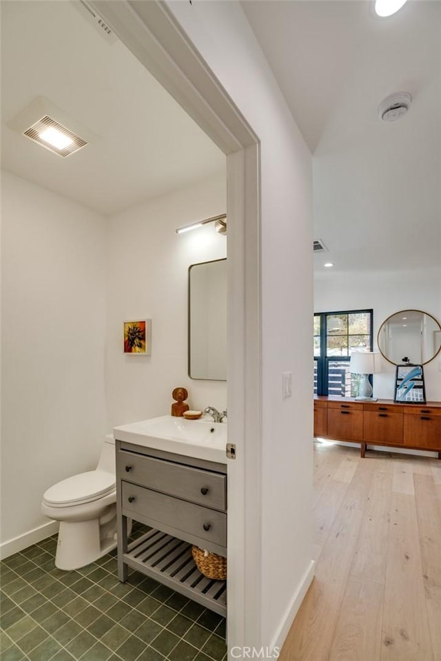 bathroom featuring vanity, hardwood / wood-style flooring, and toilet