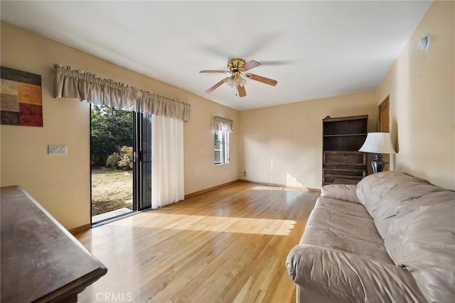 living room with light hardwood / wood-style flooring and ceiling fan