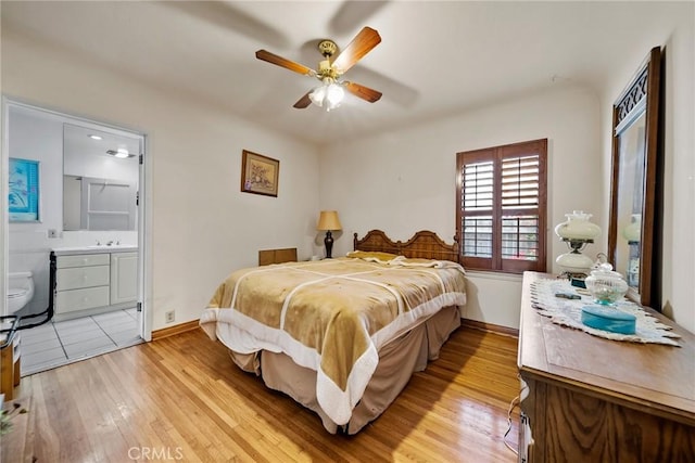 bedroom with ceiling fan, connected bathroom, sink, and light wood-type flooring