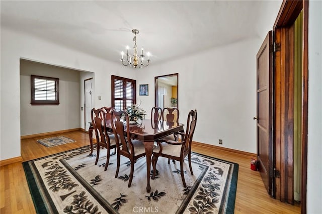 dining area with an inviting chandelier and light hardwood / wood-style floors