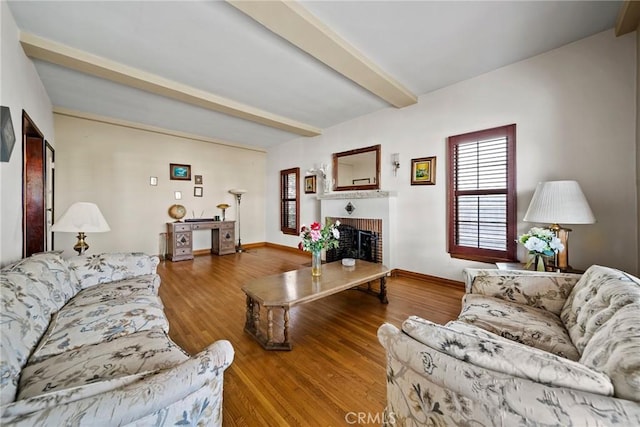 living room with hardwood / wood-style flooring, a fireplace, and beam ceiling