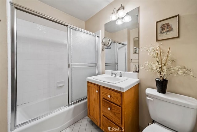 full bathroom featuring vanity, tile patterned flooring, shower / bath combination with glass door, and toilet