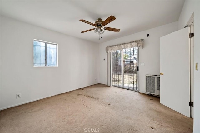 carpeted spare room with radiator heating unit and ceiling fan