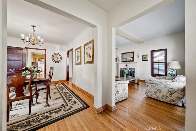 corridor with an inviting chandelier, hardwood / wood-style flooring, and beam ceiling