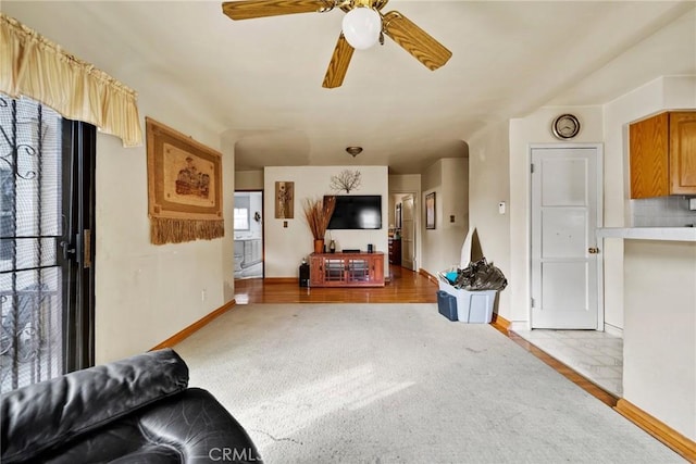 carpeted living room featuring ceiling fan and a wealth of natural light