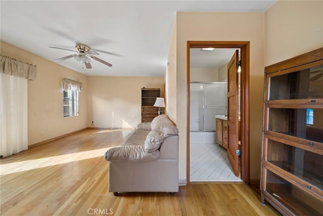 living room featuring ceiling fan and light hardwood / wood-style flooring