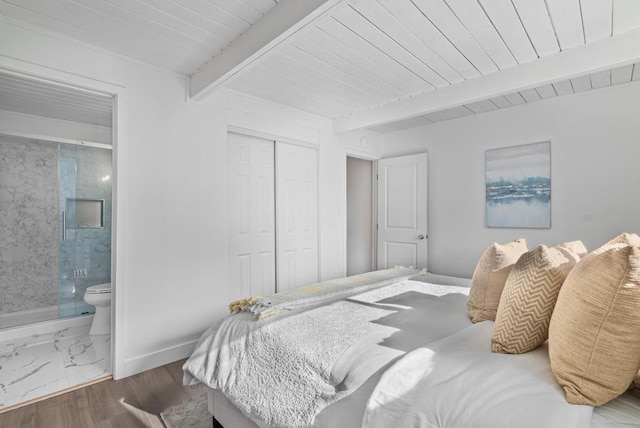 bedroom with dark wood-type flooring, beam ceiling, ensuite bathroom, wooden ceiling, and a closet