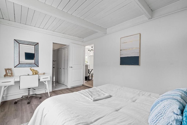 bedroom featuring hardwood / wood-style floors, wooden ceiling, and beamed ceiling