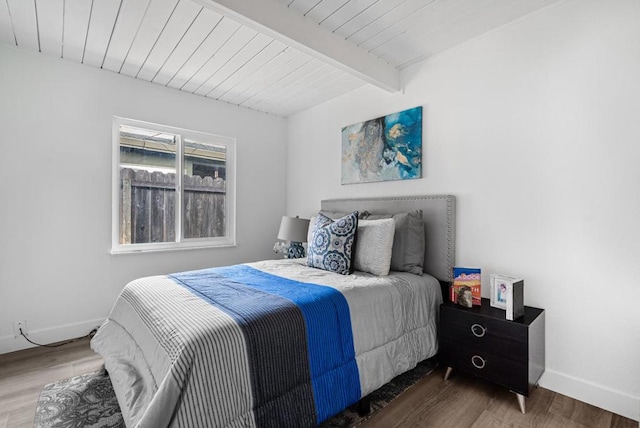 bedroom featuring beamed ceiling, hardwood / wood-style floors, and wood ceiling