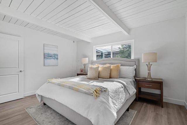 bedroom with beamed ceiling, wooden ceiling, and light wood-type flooring