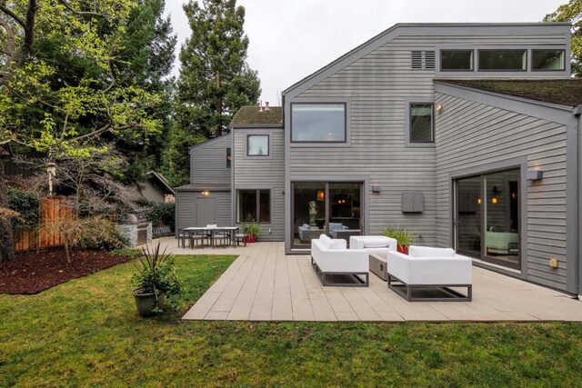 back of house featuring an outdoor living space, a patio, and a lawn