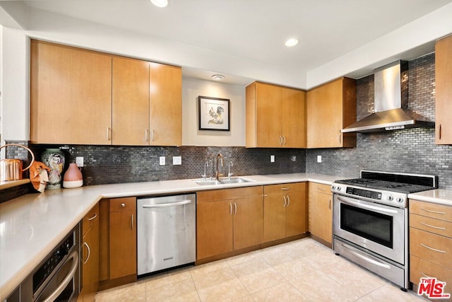 kitchen featuring sink, light tile patterned floors, appliances with stainless steel finishes, decorative backsplash, and wall chimney exhaust hood