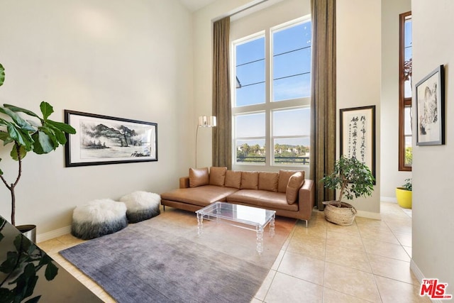 living room featuring light tile patterned floors and a towering ceiling