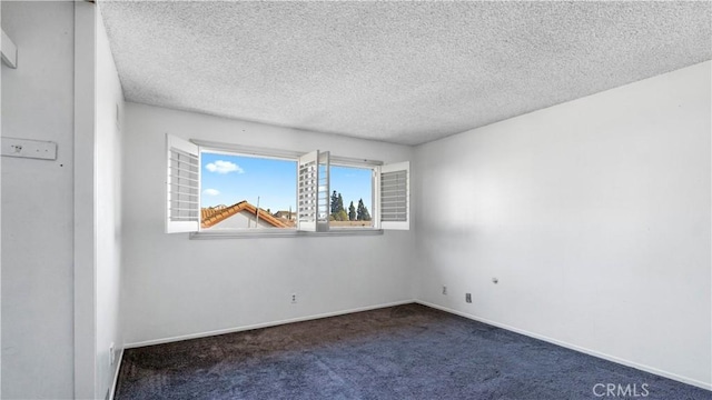 carpeted empty room featuring baseboards and a textured ceiling