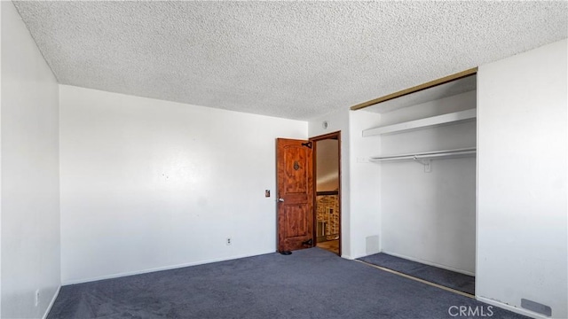 unfurnished bedroom with a textured ceiling, a closet, and carpet flooring