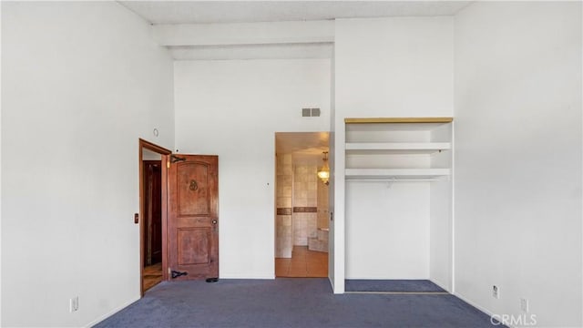 unfurnished bedroom featuring a closet, carpet flooring, and visible vents