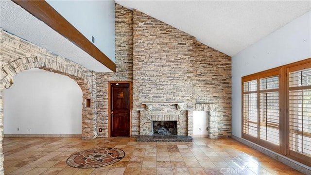 unfurnished living room featuring high vaulted ceiling, a stone fireplace, baseboards, and tile patterned floors