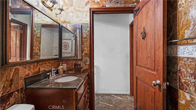 half bath featuring marble finish floor and vanity