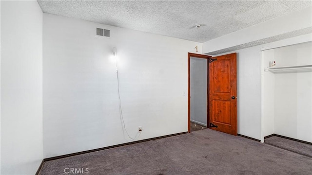 unfurnished bedroom featuring a closet, visible vents, carpet flooring, a textured ceiling, and baseboards