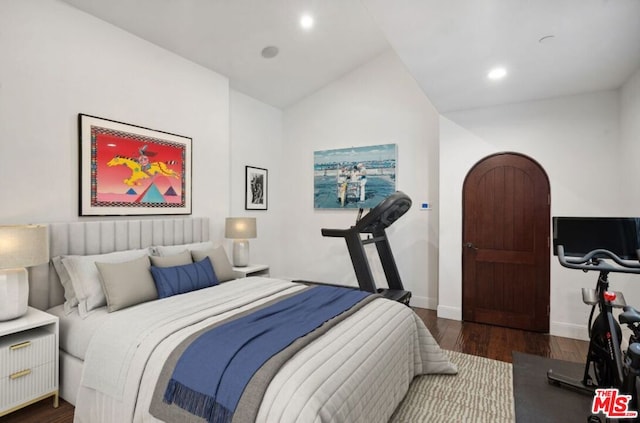 bedroom with dark wood-type flooring and vaulted ceiling