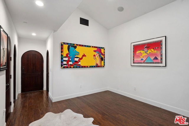 spare room with lofted ceiling and dark hardwood / wood-style flooring